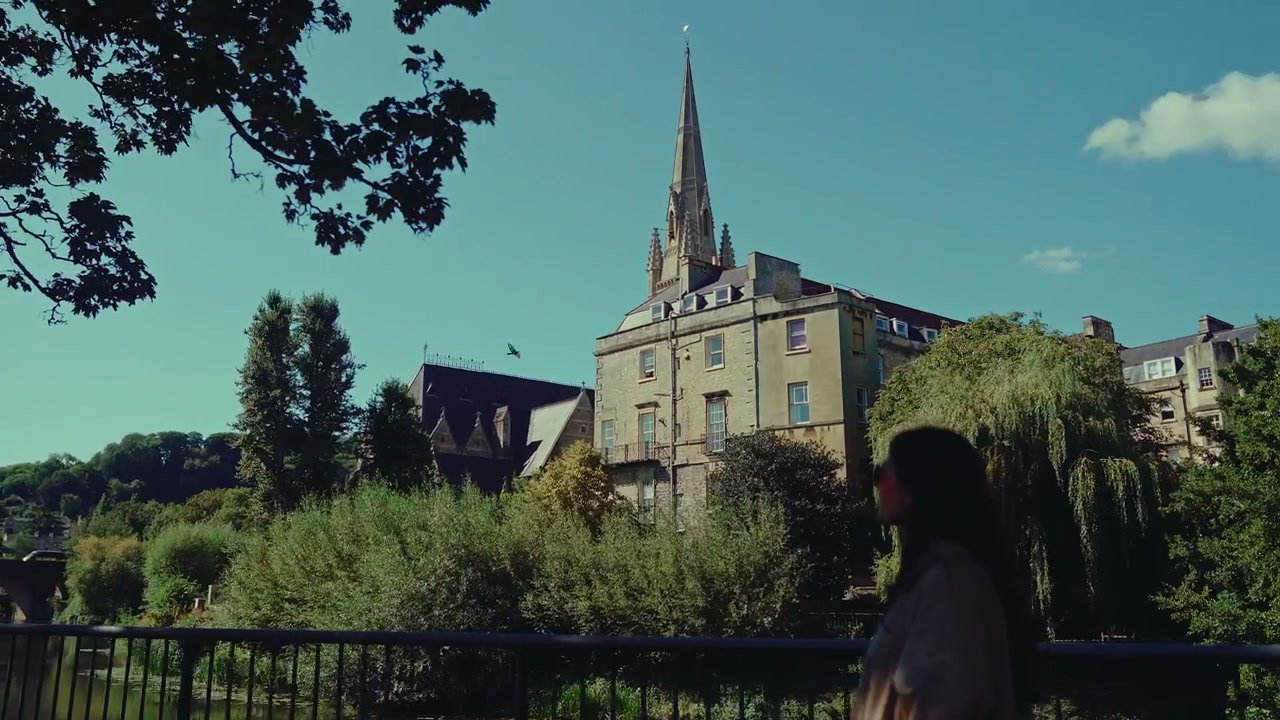 Woman Walks by Historic Spire in Bath