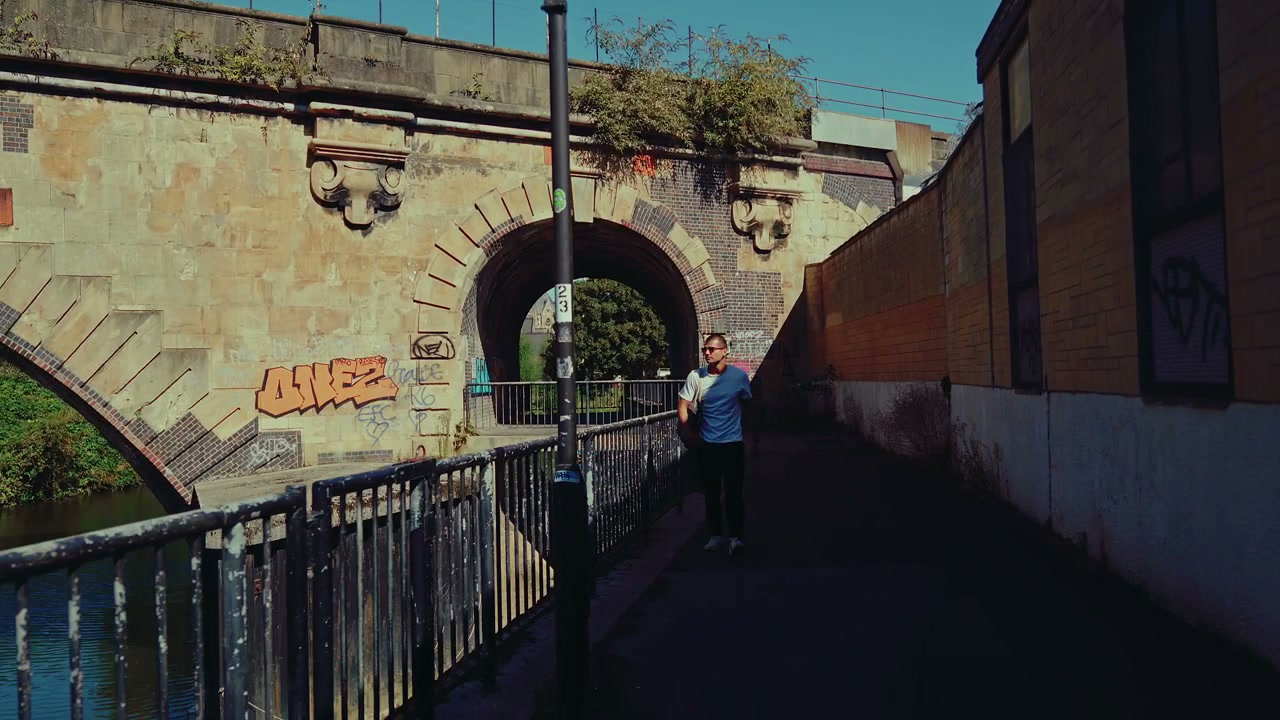Man Walks Under Historic Bridge in Bath
