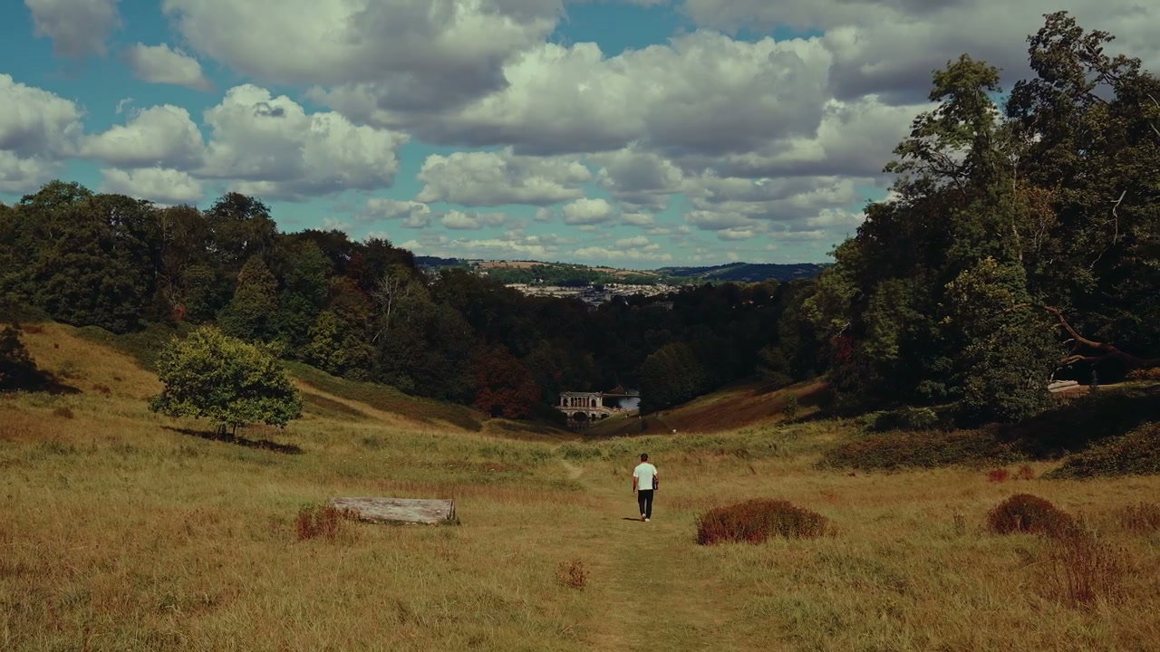 Person Walks Through Grassy Valley Overlooking Bath