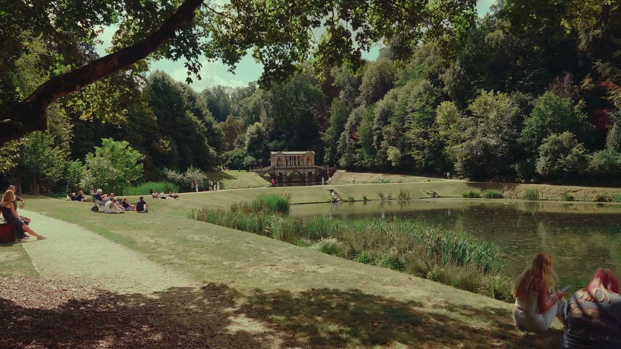 People Relaxing by Lake with Palladian Bridge