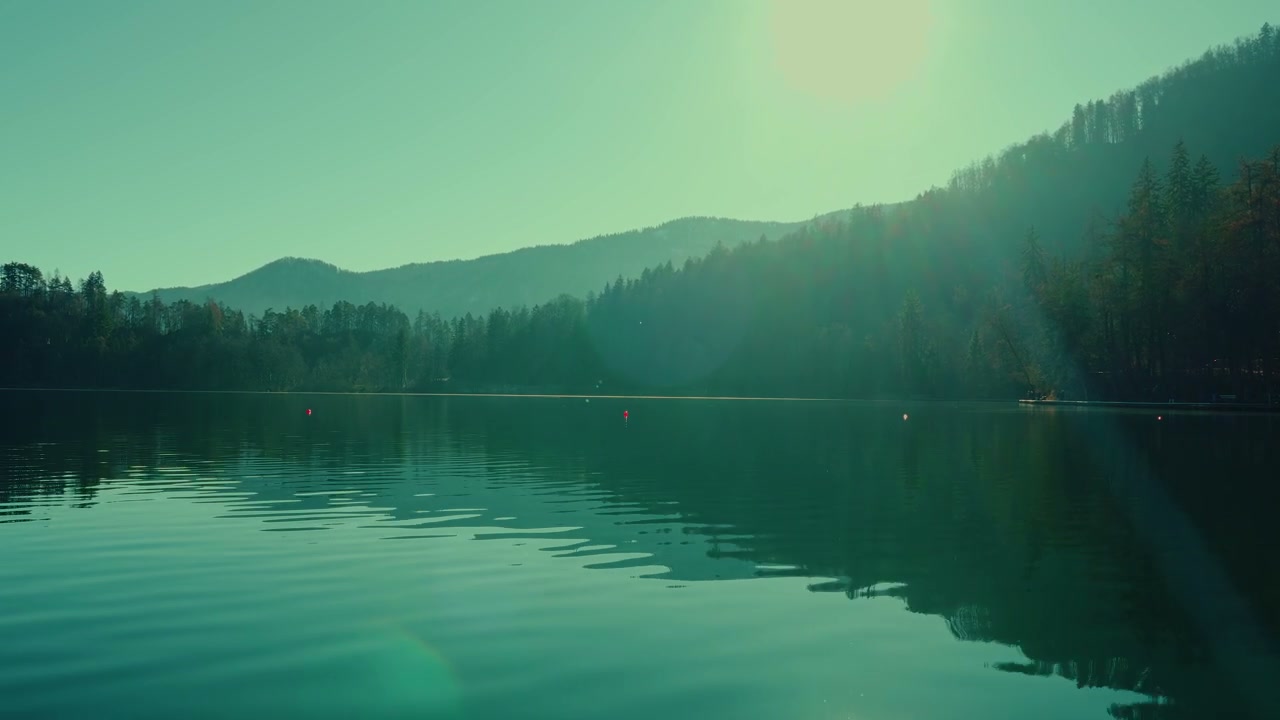 Calm Lake Bled with Sun Above Mountains