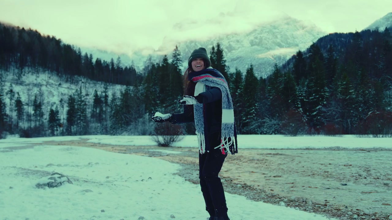 Woman Throwing Snow in Winter Mountain Landscape