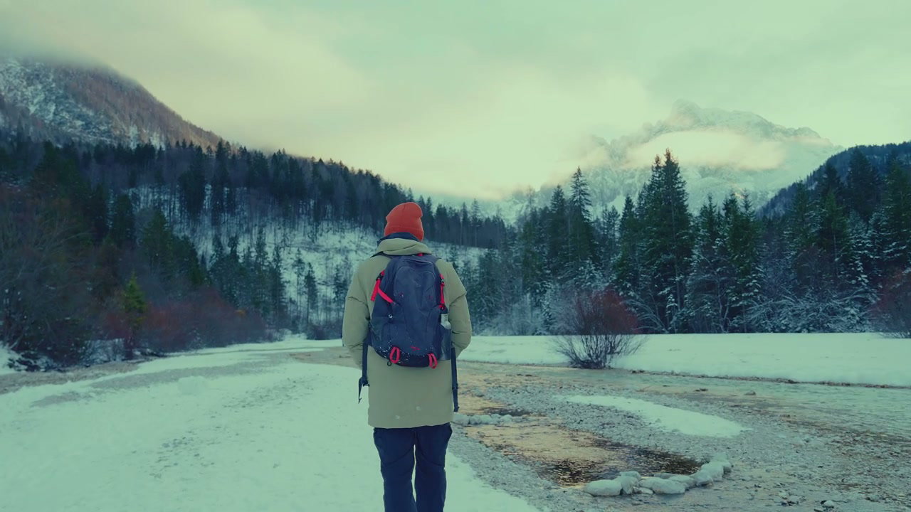 Hiker Walking in Snowy Mountain Landscape