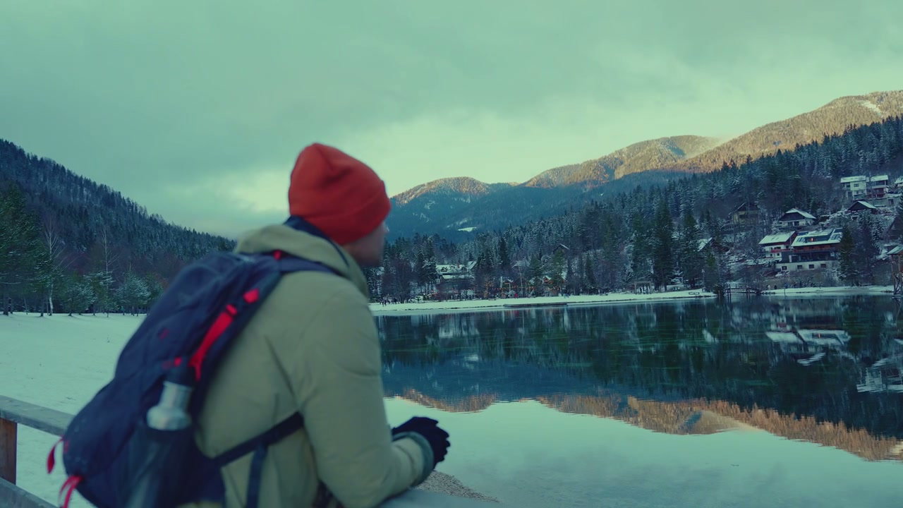 Hiker Looks at Snowy Lake Jasna