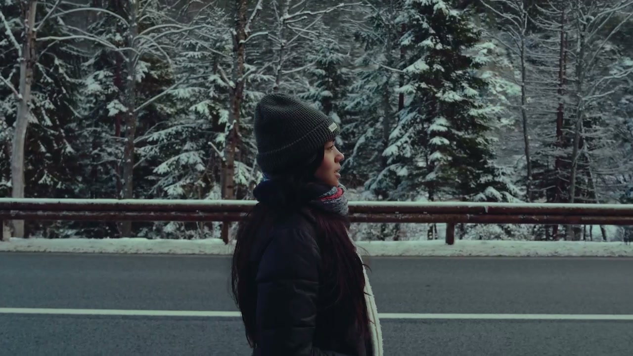 Woman Walking by Snowy Road in Winter Forest