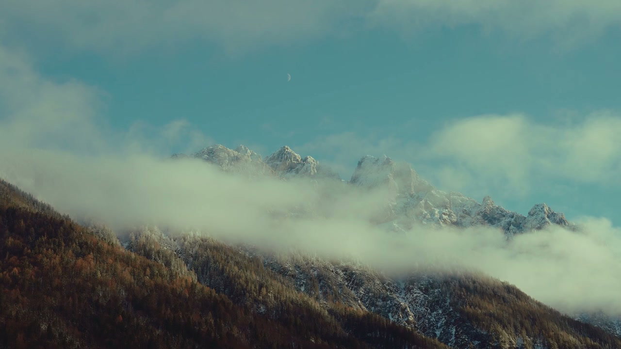 Snowy Mountain Peaks with Clouds and Moon