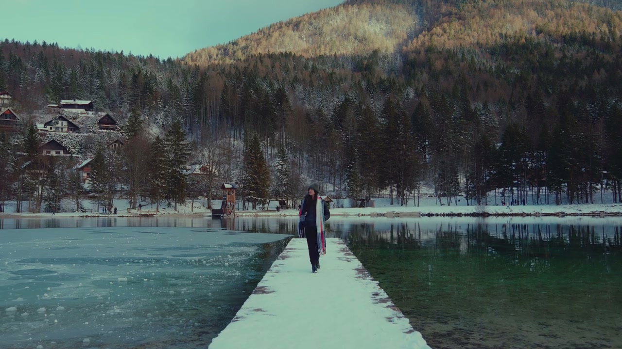 Person Walks on Snowy Pier at Lake Jasna