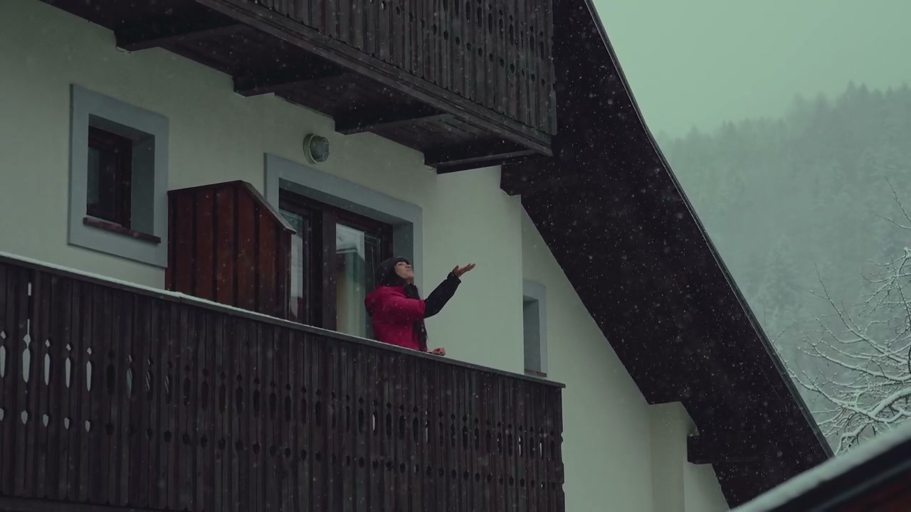 Person on Balcony Enjoying Winter Snowfall