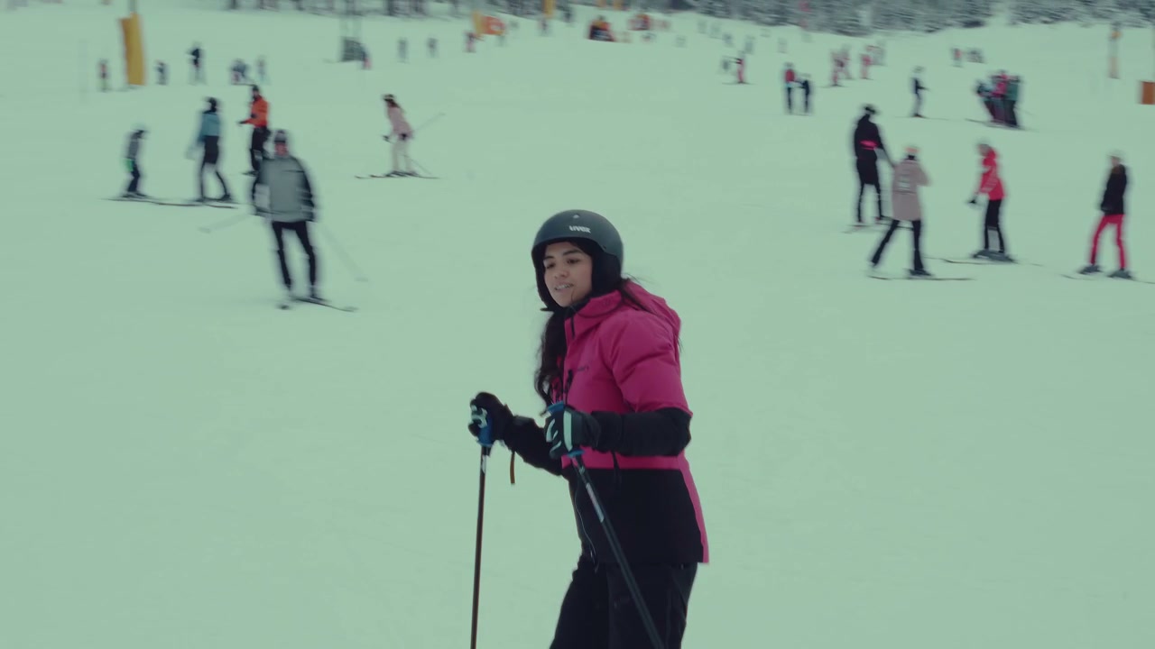 Young Woman Skiing Down Snowy Mountain