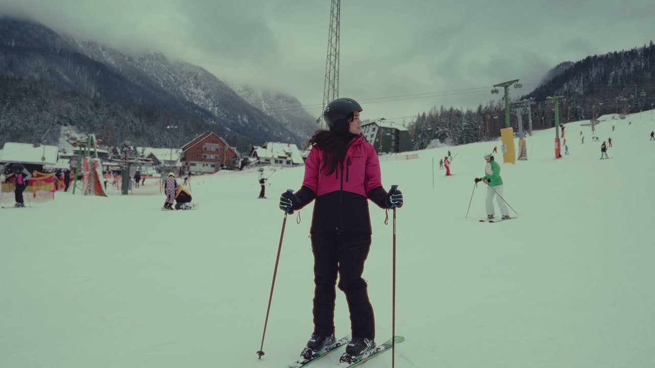 Skier Standing on a Ski Slope with Mountains