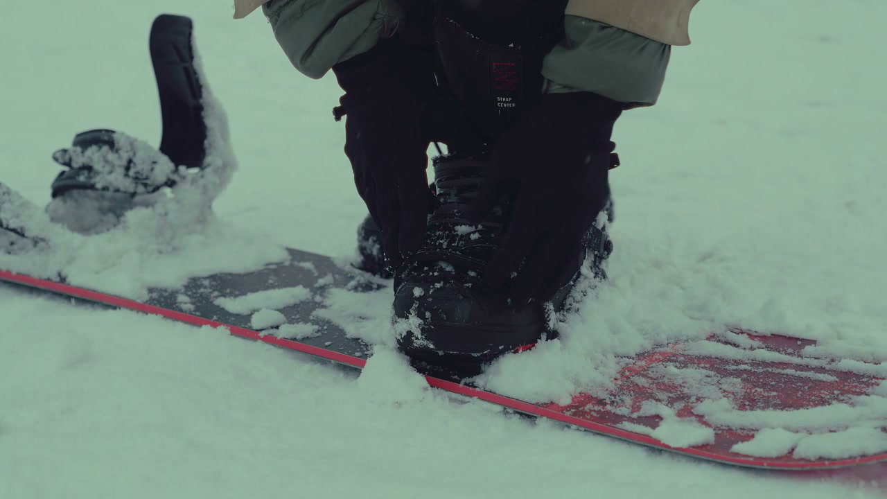 Snowboarder Adjusting Binding