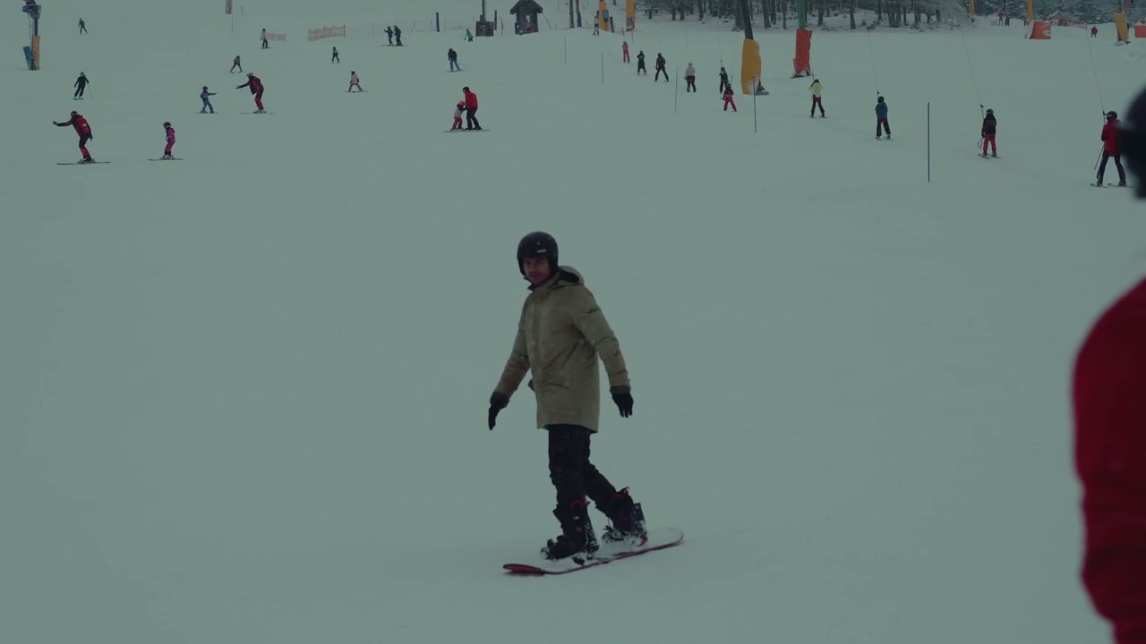 Man Snowboarding Down a Ski Slope