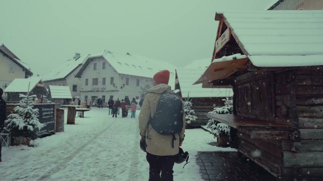 Person Walking on Snowy Village Street
