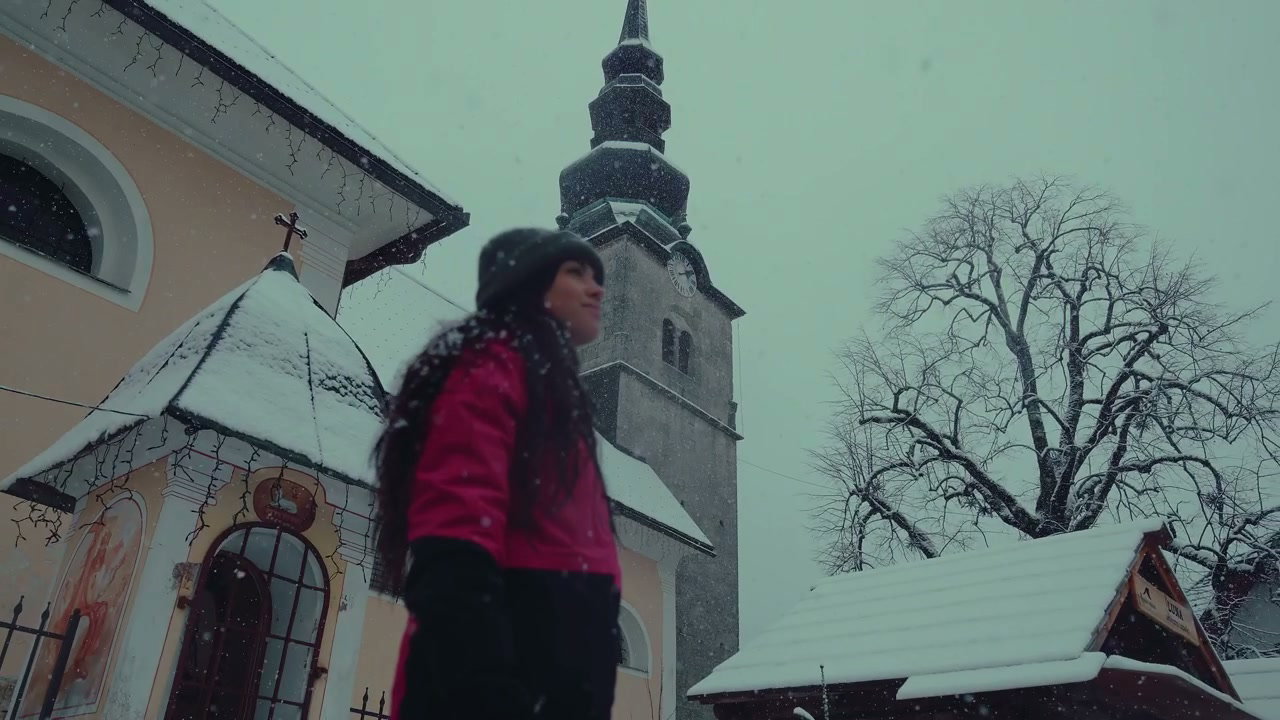 Woman Enjoying Snowfall Near Church