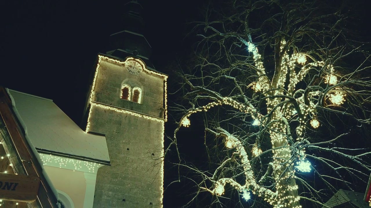 Illuminated Church Tower and Festive Tree at Night