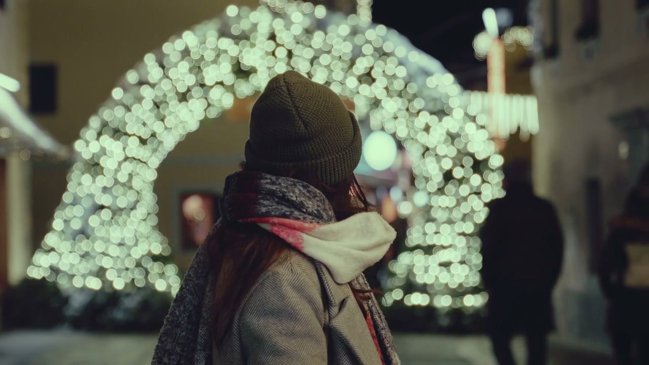 Young Woman Smiling by Festive Lights Archway