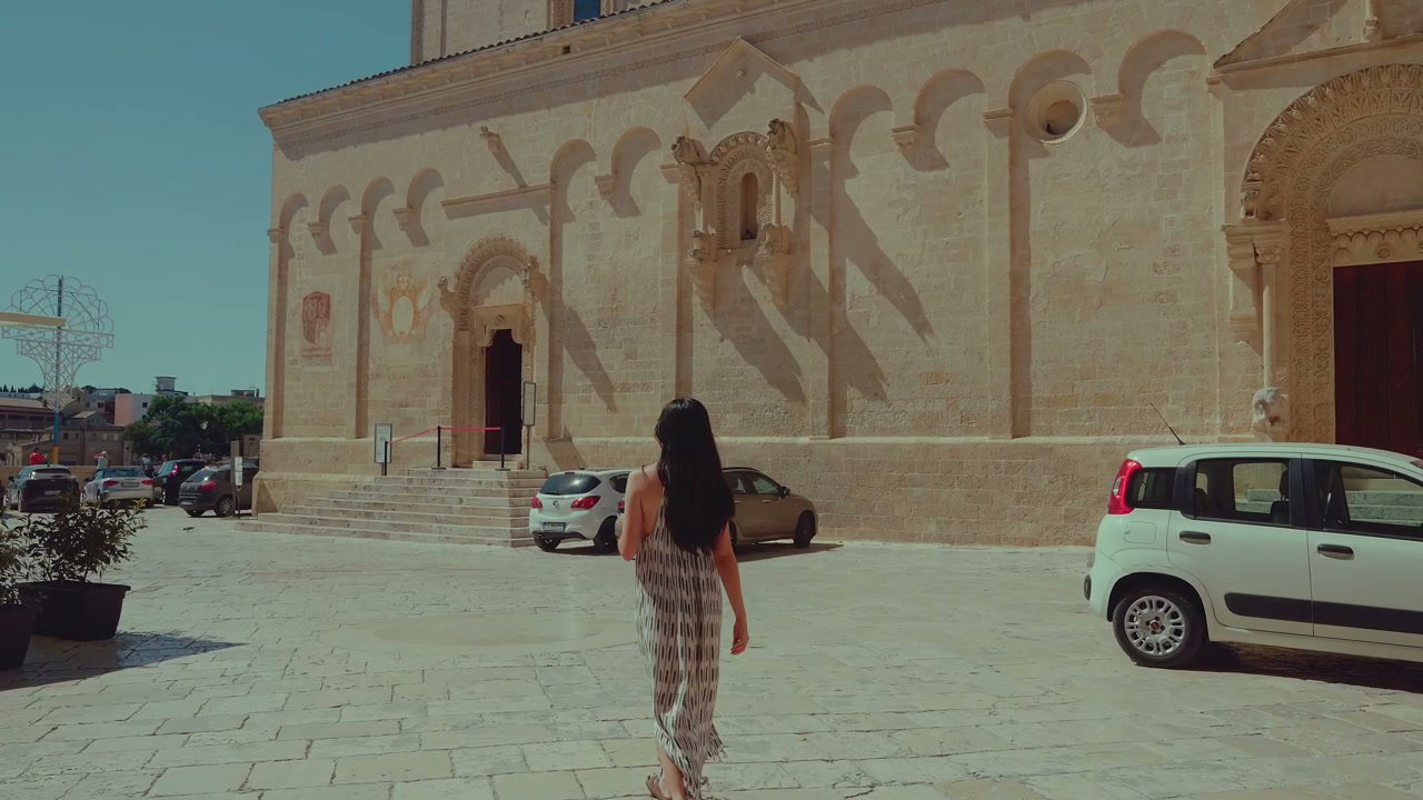 Woman Walking Towards Historic Matera Cathedral
