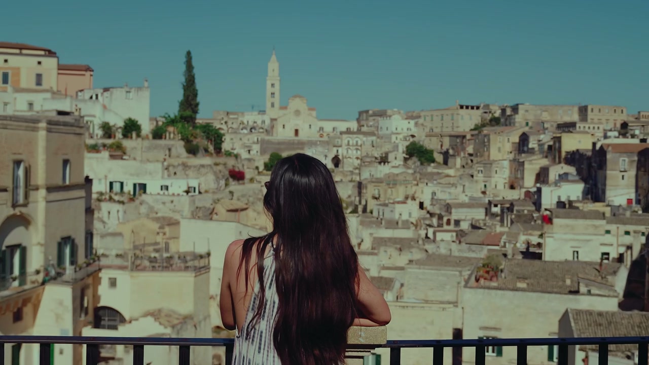 Woman Overlooking Matera Cityscape