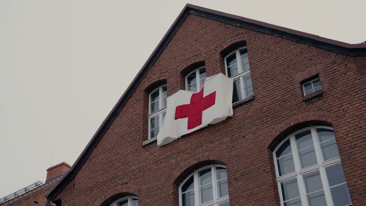 Red Cross Flag on Brick Building Window