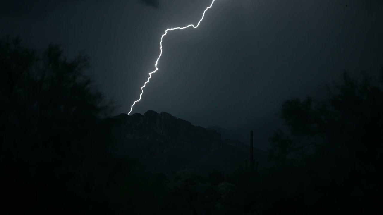 Lightning Strikes Mountain Peak At Night