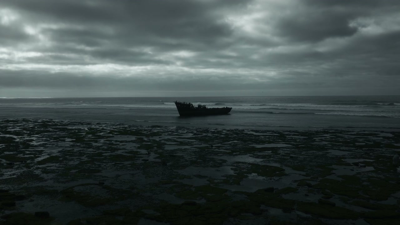 Eerie Shipwreck On Rocky Beach Under Dark Sky