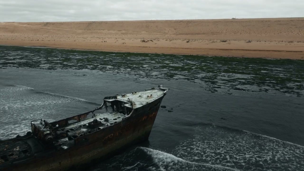Rusted Shipwreck Washed Ashore on Desert Coast