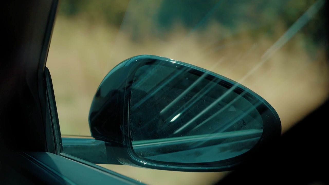 Car Side Mirror Reflecting Country Road