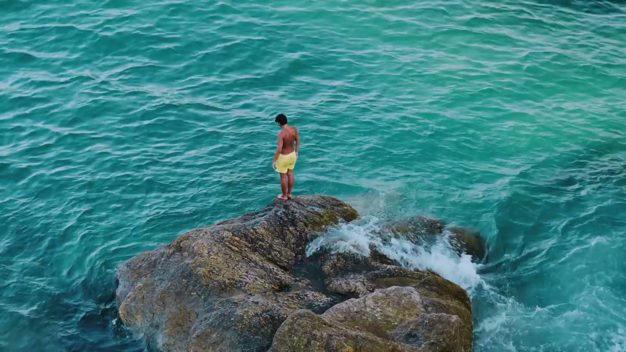 Man Jumping Into Ocean From Rocks