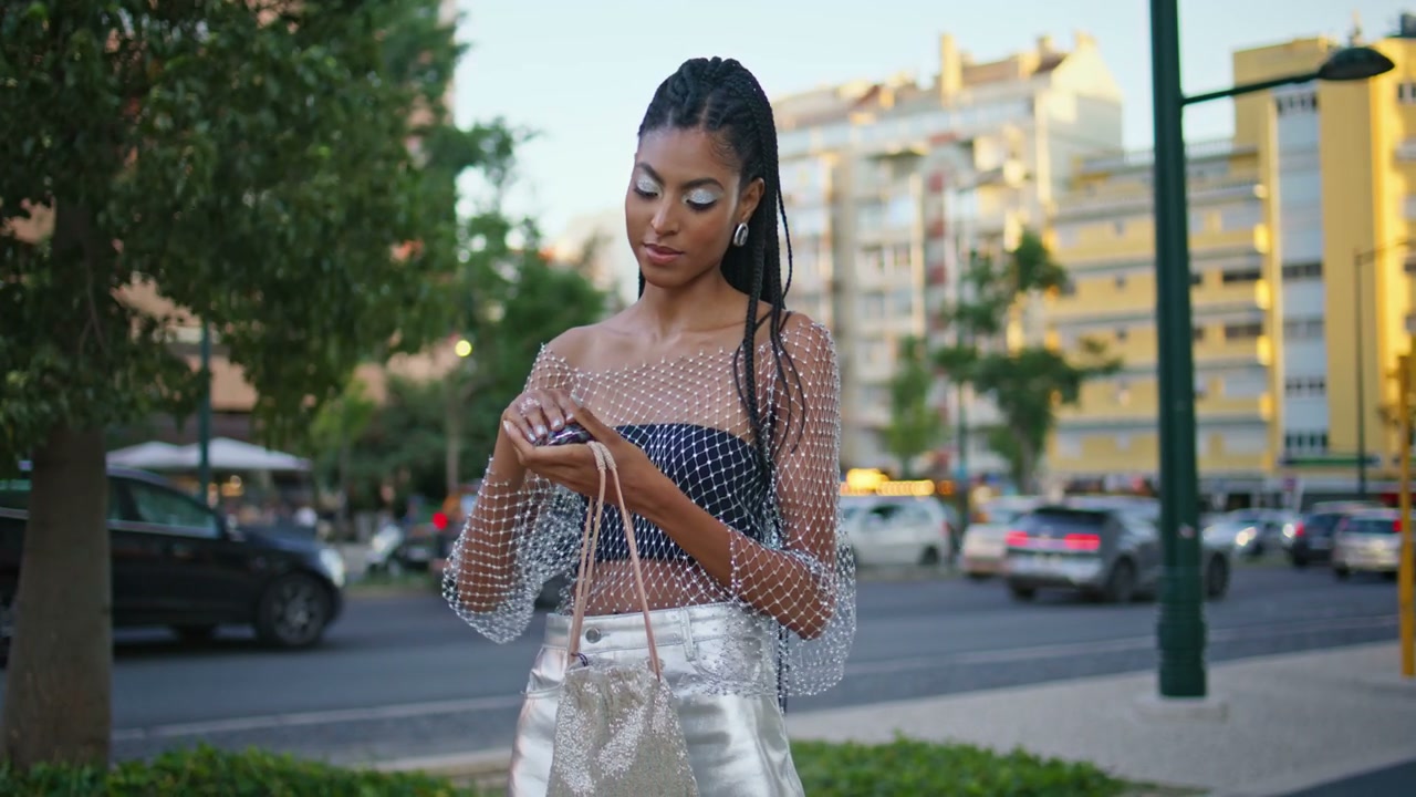 Stylish Woman Adjusting Makeup on City Street