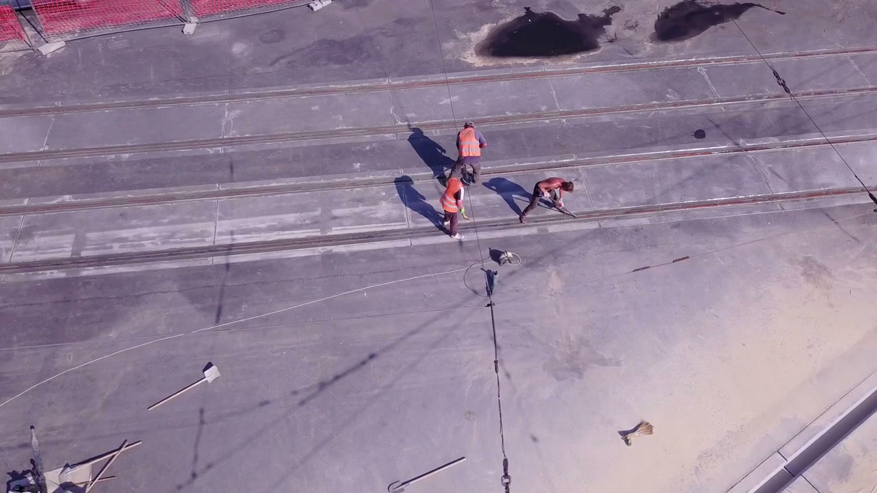 Construction Workers Repairing Tracks Overhead
