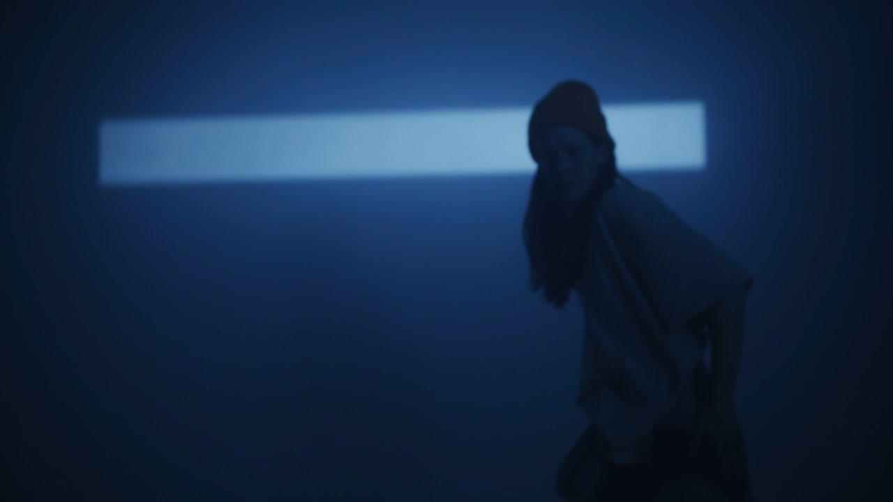 Dancer Performs Under Moving Blue Spotlight