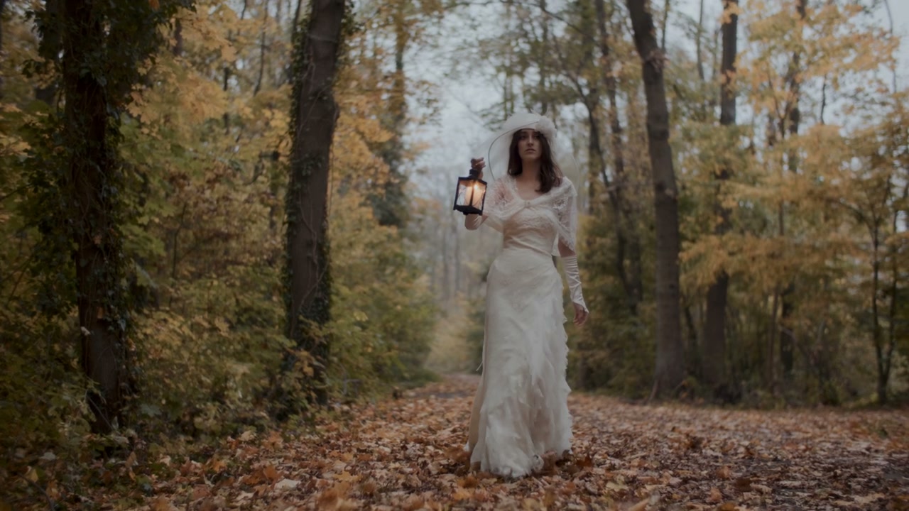 Woman in White Dress with Lantern in Autumn Forest