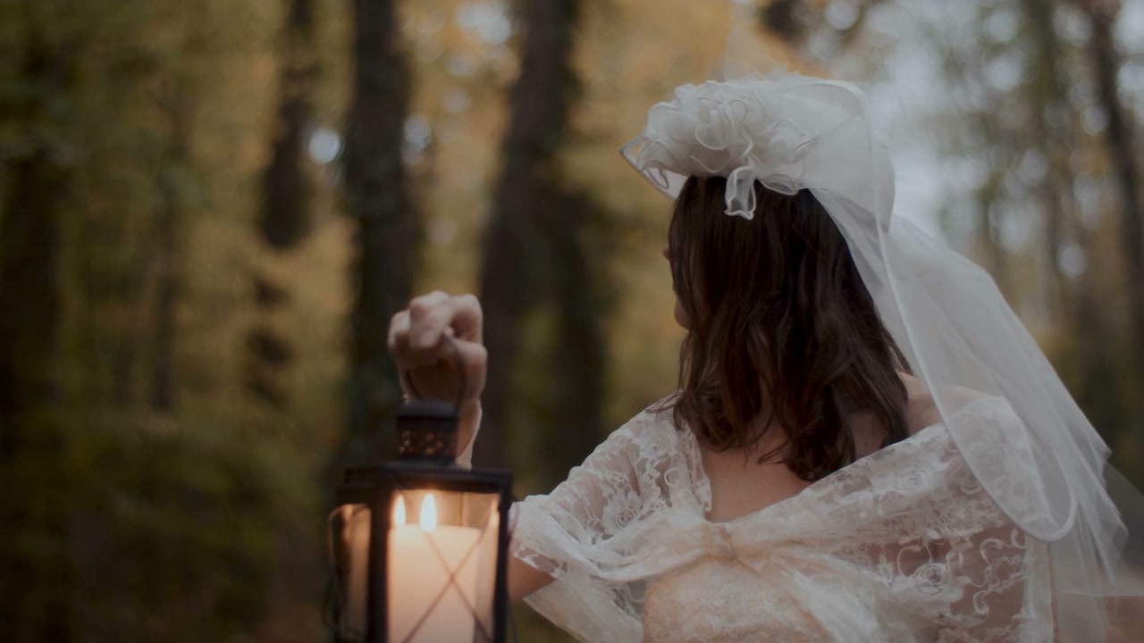 Woman in White Dress Holding Lantern in Forest