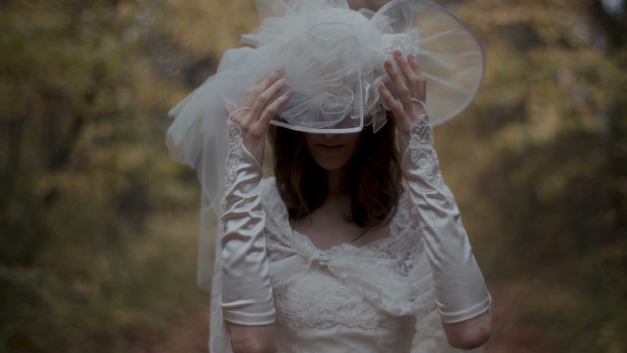 Woman in Wedding Dress Adjusting Veil