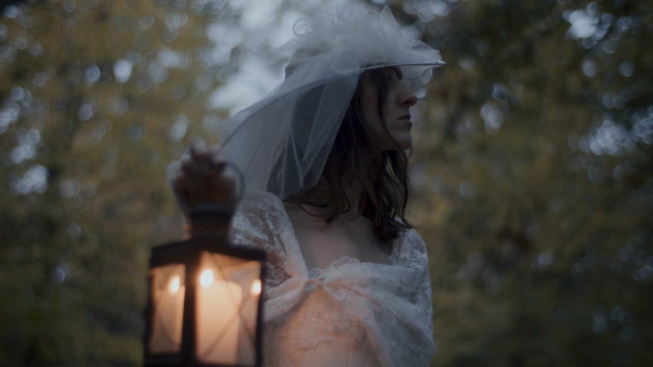 White Lady Holding Lantern in Dark Woods