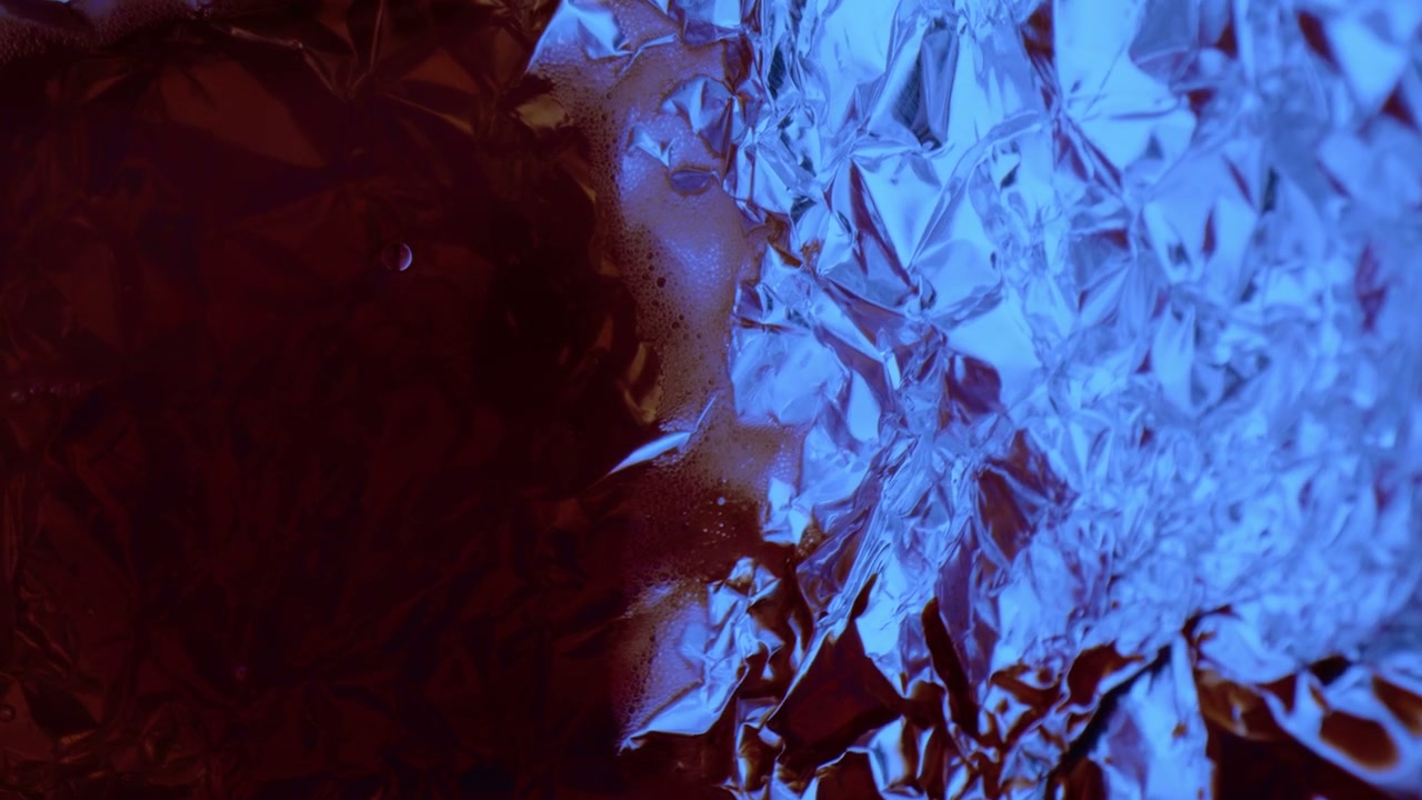 Red Liquid Flowing on Crumpled Blue Foil