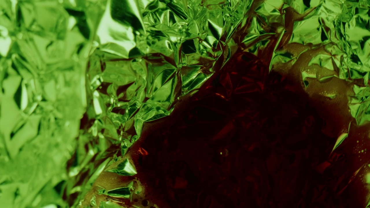 Red Liquid Flowing on Green Crumpled Foil