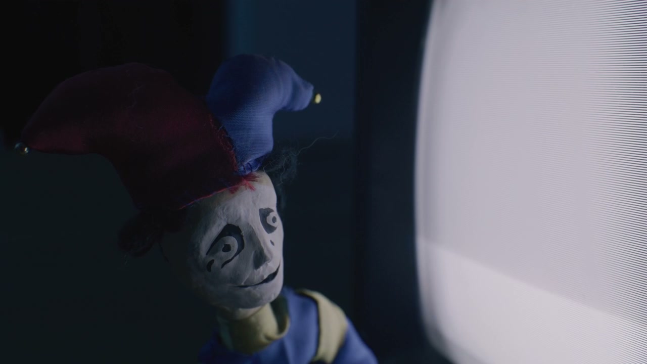 Creepy Jester Puppet Watching Static TV