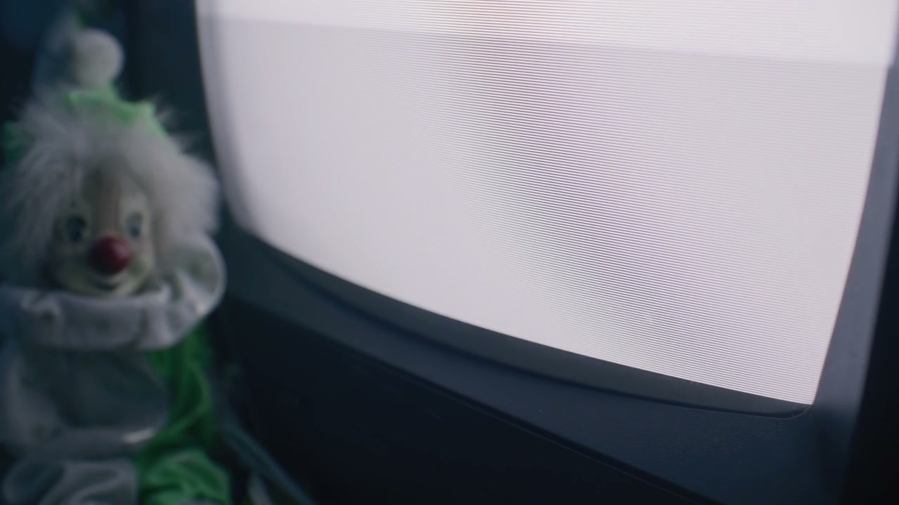 Creepy Clown Doll Next to Static TV