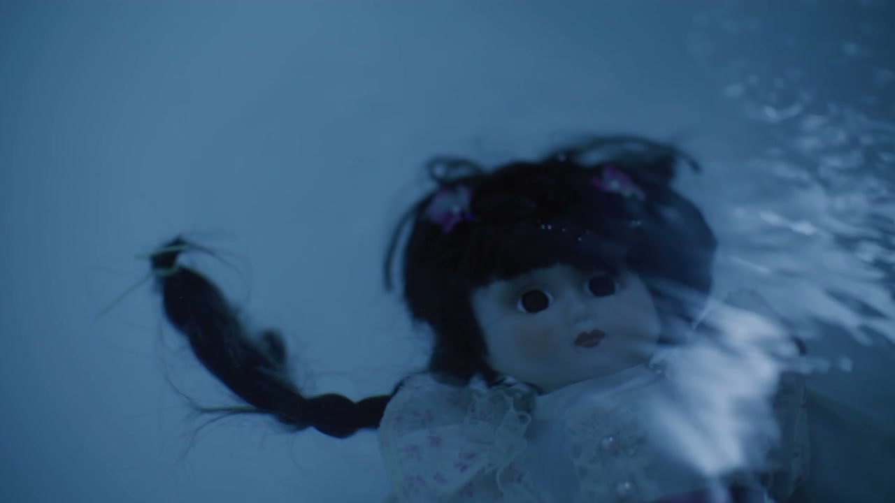 Doll Floating in Dark Water