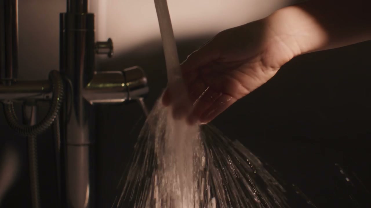 Hand Turning Off Water From Shower Faucet