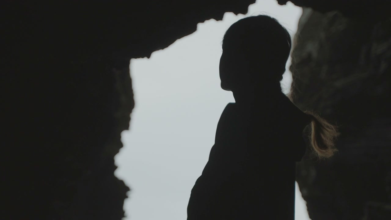 Person Silhouetted in Coastal Cave