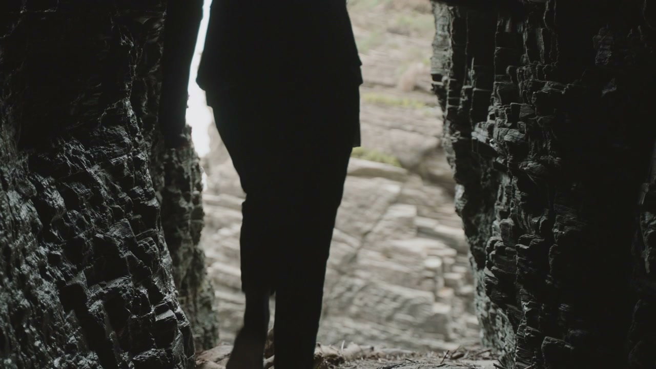 Person Walking Out of Coastal Cave