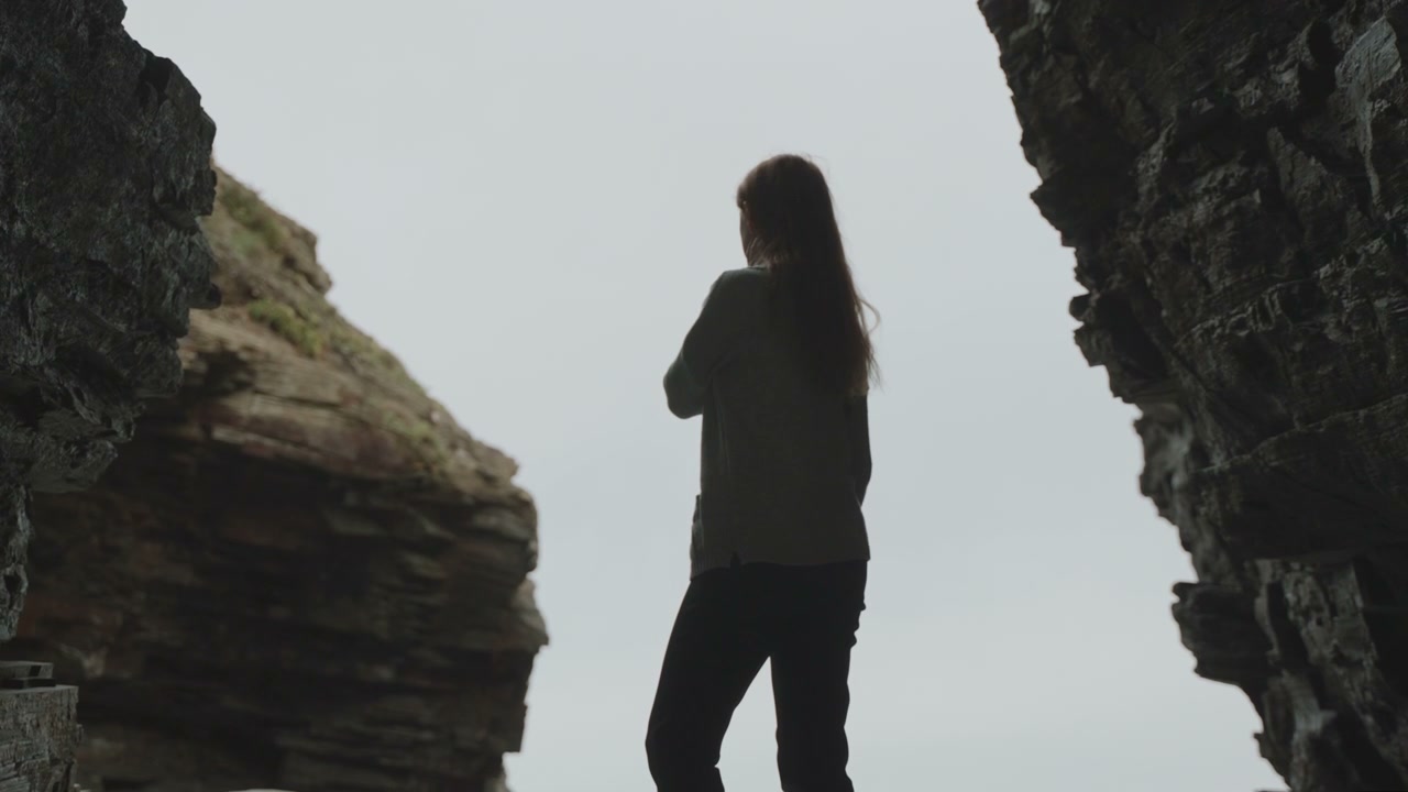 Woman Silhouette Between Coastal Cliffs