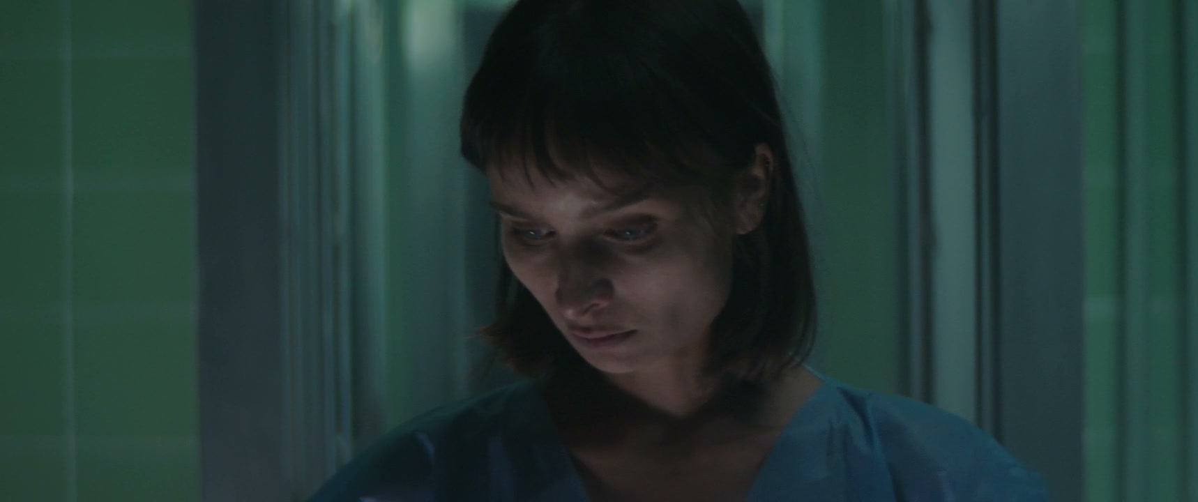 Scared Woman Runs in Dark Hospital Corridor