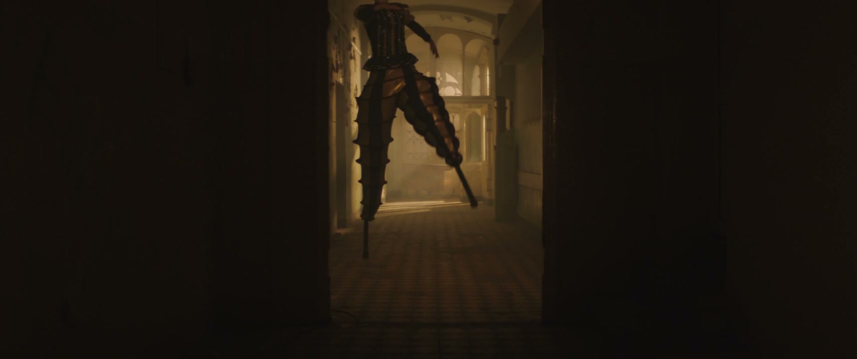 Creepy Jester on Stilts in Dark Hallway