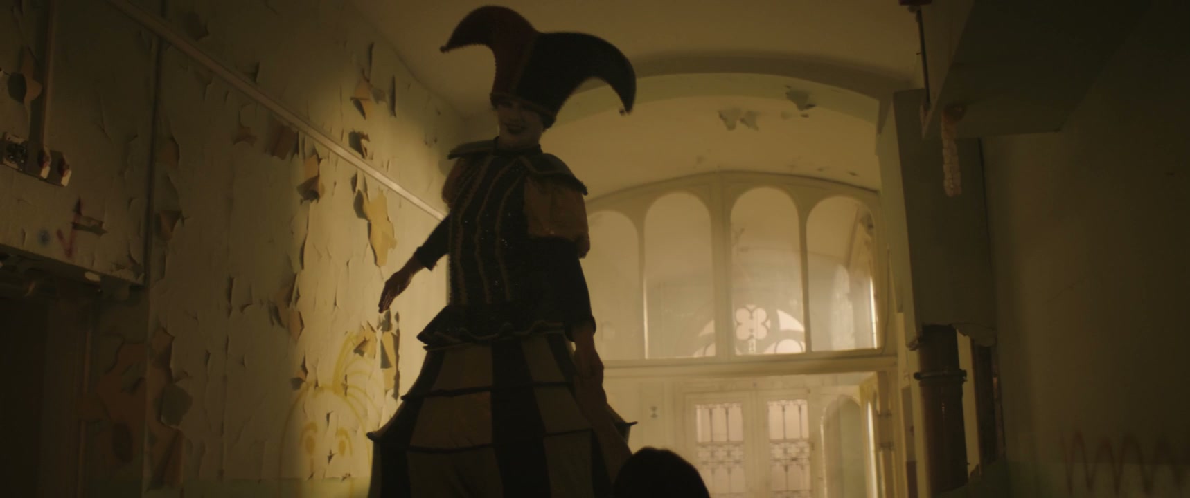 Eerie Jester on Stilts with Person in Hospital