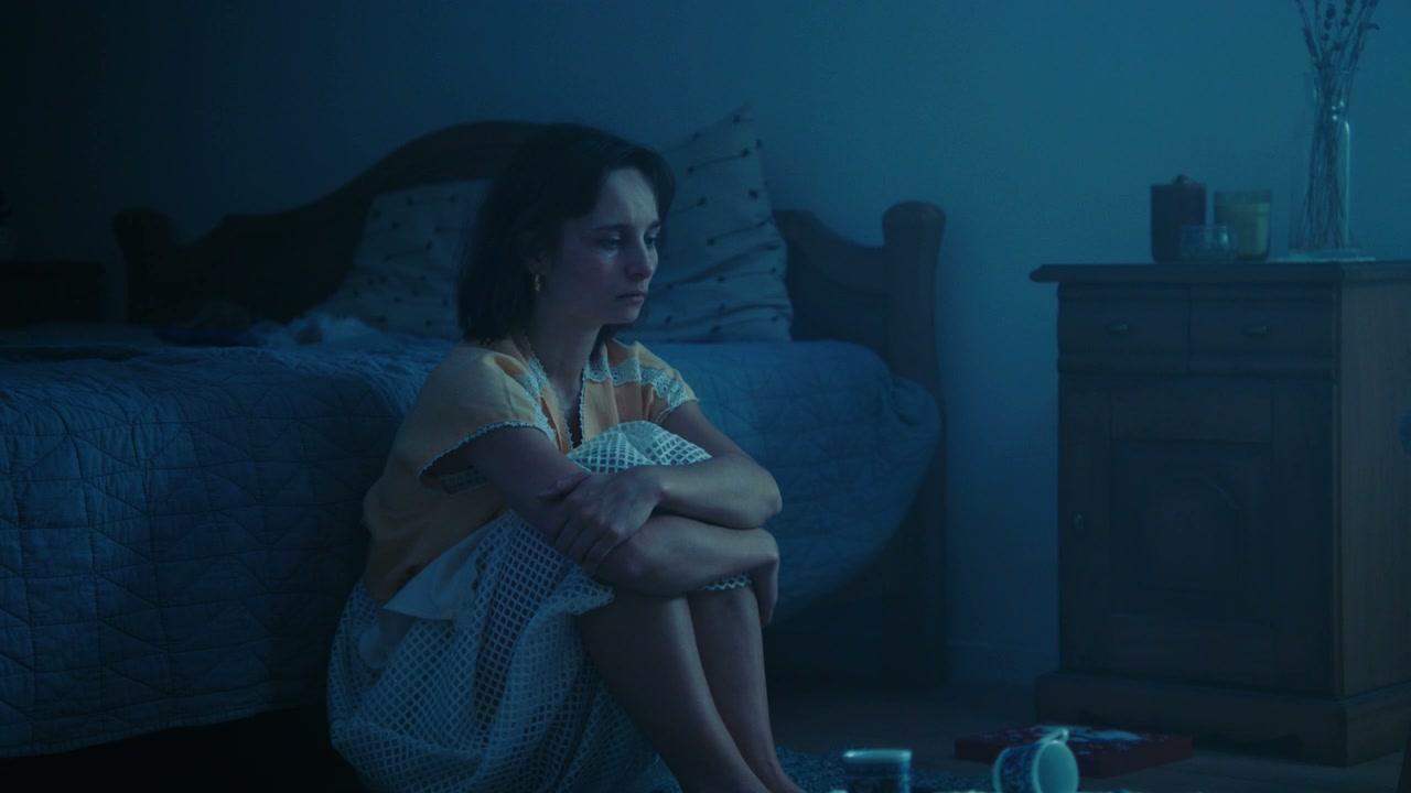 Distressed Woman Sitting in Bedroom