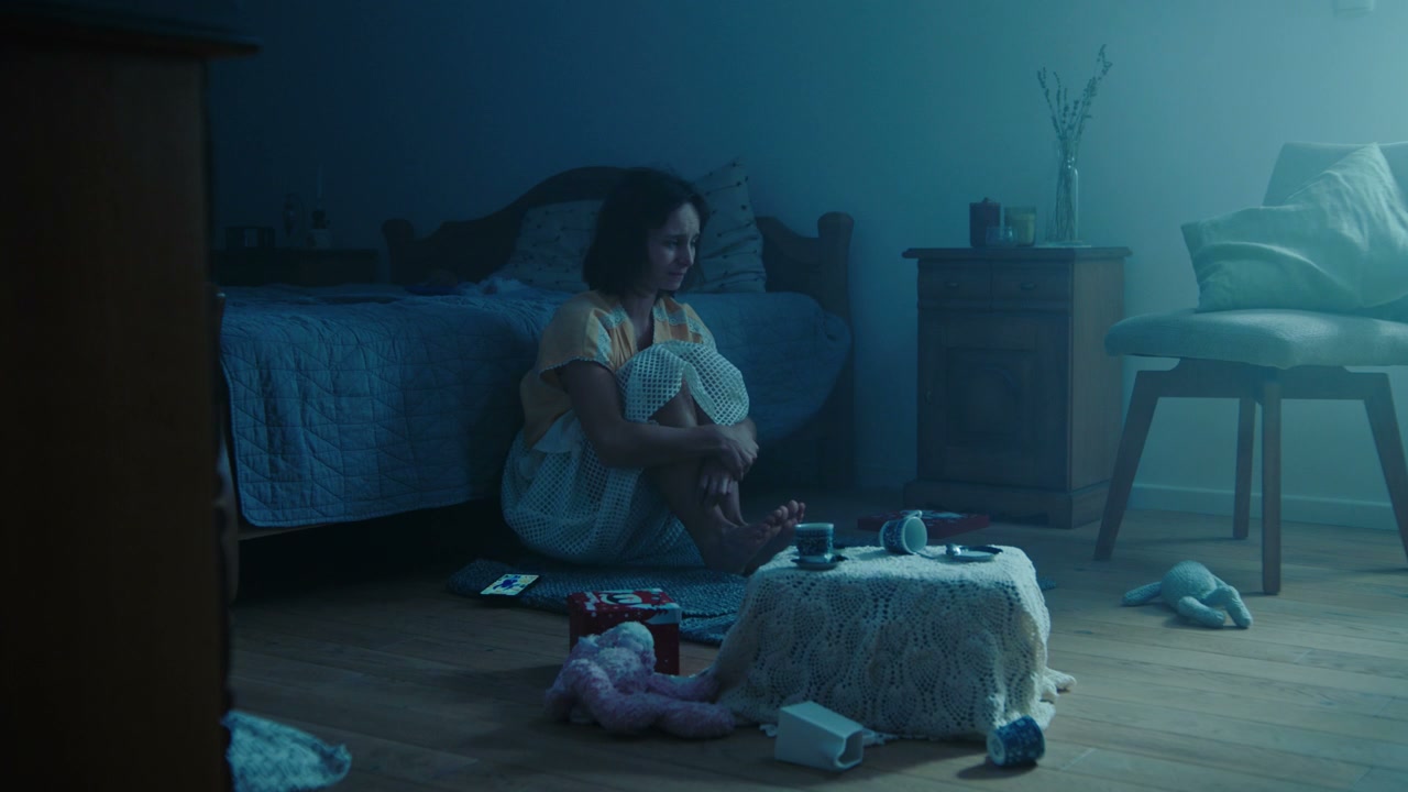 Distressed Woman in Dark Bedroom