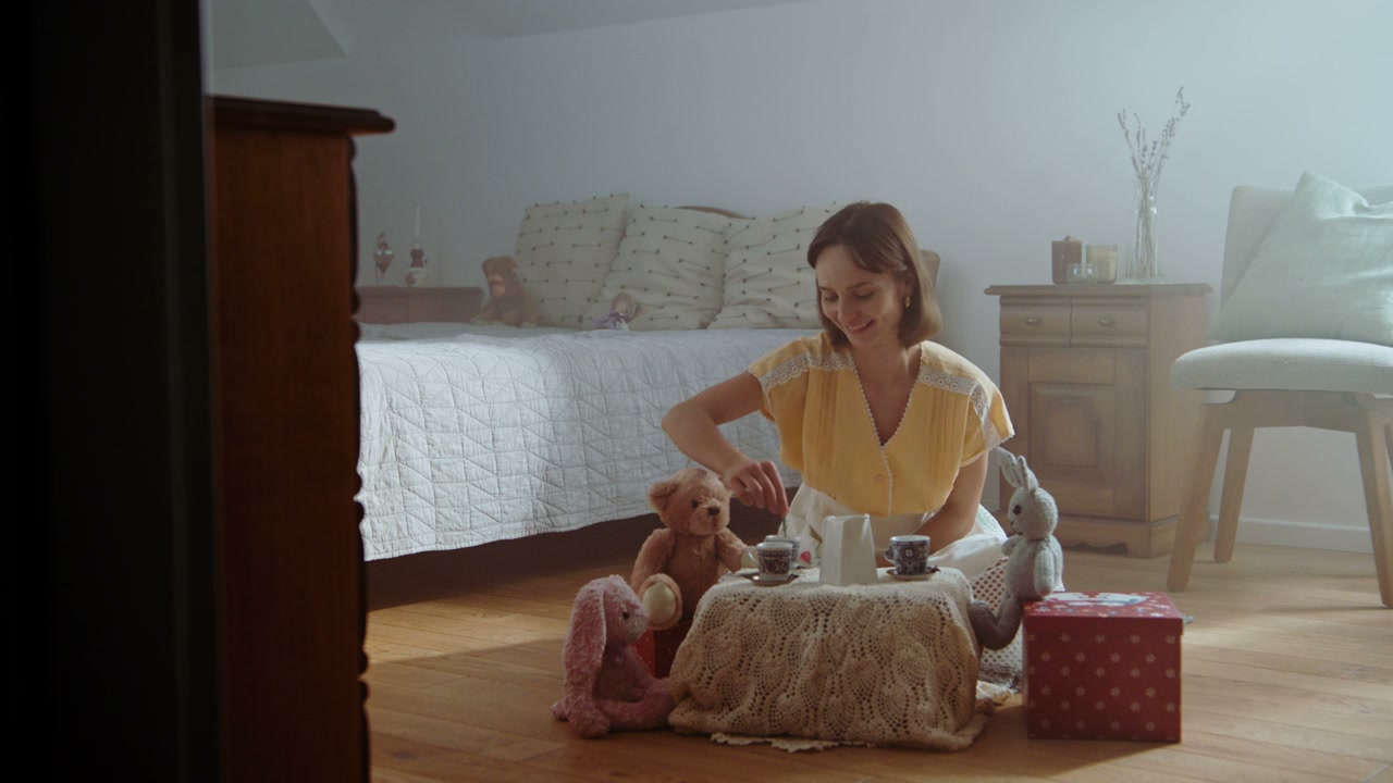 Young Woman Playing Tea Party with Stuffed Animals